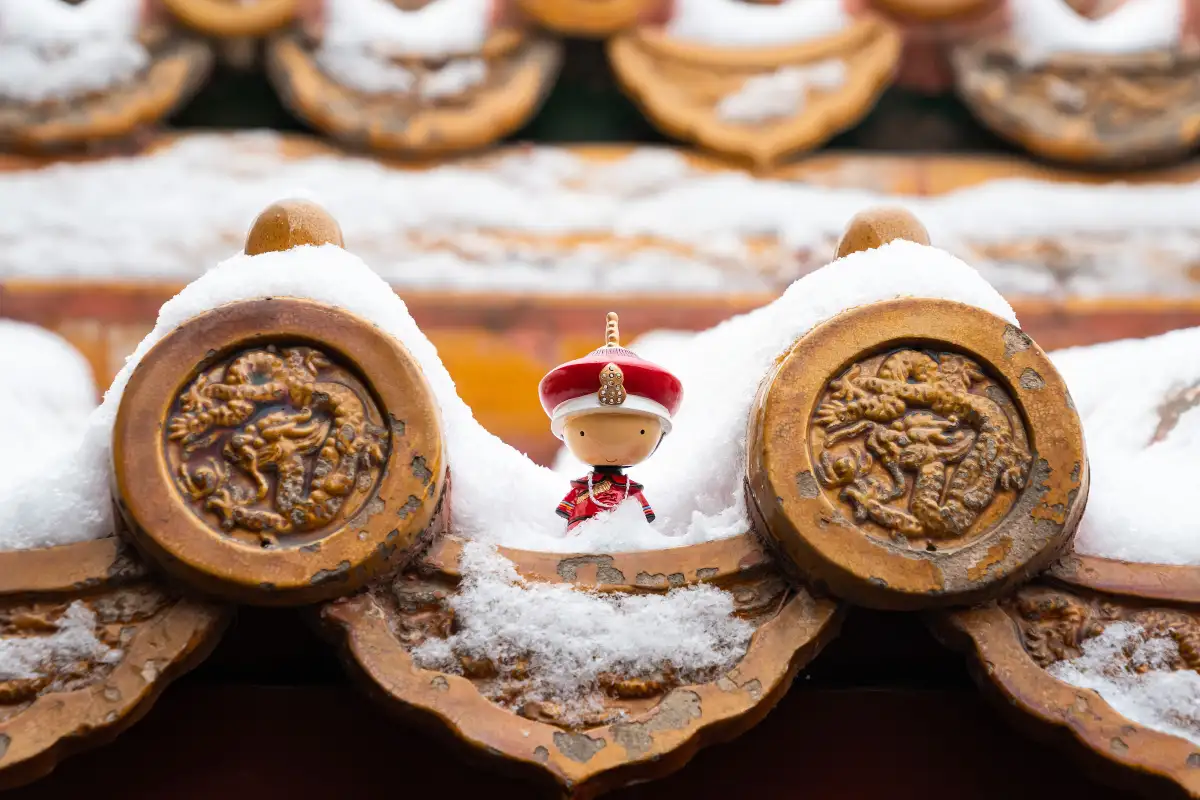 Snow-topped roof tiles with a tiny imperial figurine